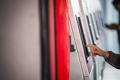 Cropped hand using kiosk at subway station