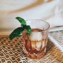 Close-up of brown clear drink on woven textile