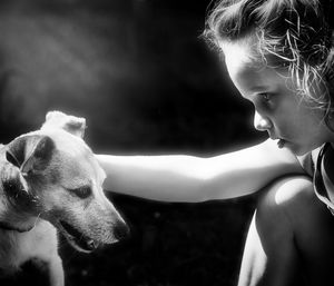 Rear view of girl with dog looking away