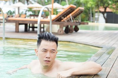 Portrait of shirtless man swimming in pool