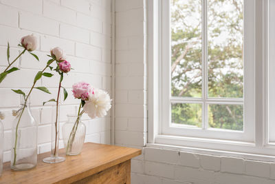 Flower vase against window at home