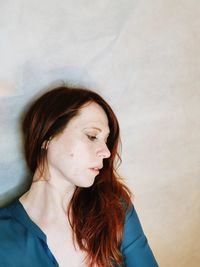 Portrait of young woman against wall