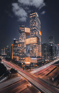 Illuminated buildings in city against sky at night