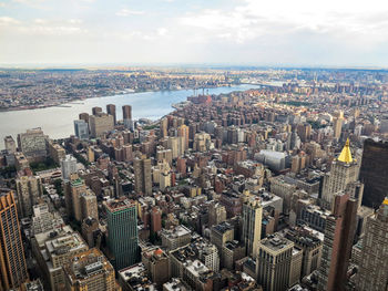 High angle view of city buildings against cloudy sky