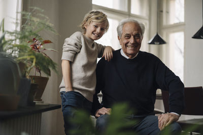 Portrait of happy grandfather and grandson at home