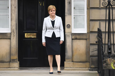 Portrait of woman standing against door