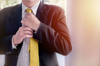 Midsection of businessman wearing suit standing at home