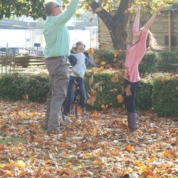 Full length of father and daughter standing by trees during autumn