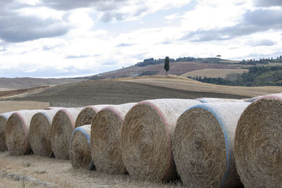 Hay bales on field against sky