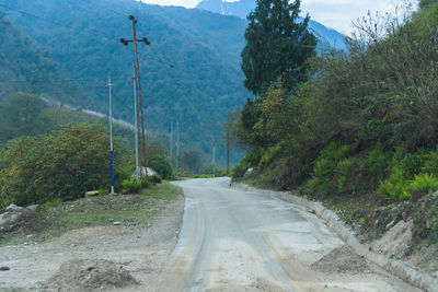 Road amidst trees against sky