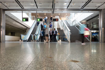 People walking on escalator in building