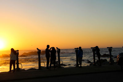 Silhouette people on beach against clear sky during sunset in california 