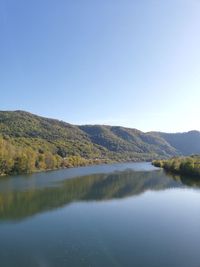 Scenic view of lake against clear blue sky