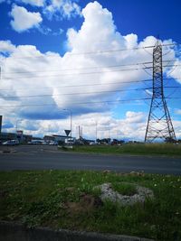 Electricity pylon on field against sky