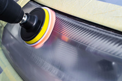 Close-up of headlights being polished on car