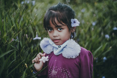 Portrait of cute girl lying on field