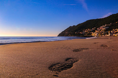 Scenic view of beach against clear blue sky