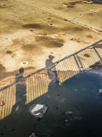 Reflection of people on puddle at beach