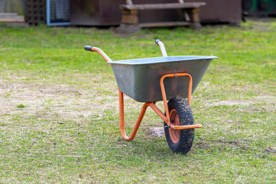 Wheelbarrow closeup on a lawn in garden, work in garden, garden maintenance