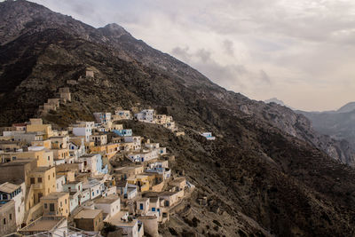 Houses on mountain against sky 