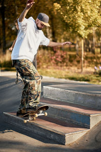 Man on skateboard over steps in park