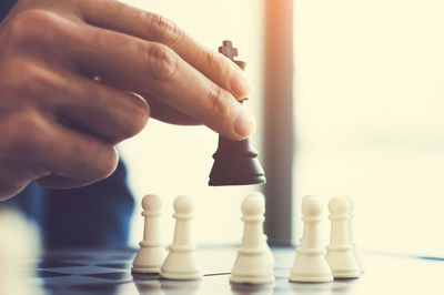 Cropped hand of person holding chess piece