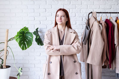 Young woman standing against wall