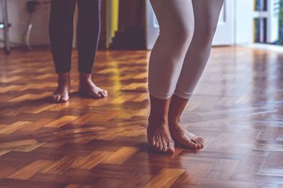 Low section of women standing on hardwood floor