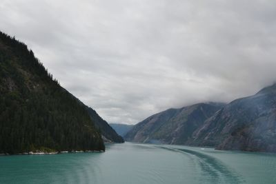 Scenic view of lake by mountains against sky