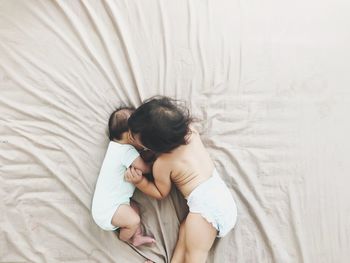 Directly above shot of babies playing on bed