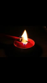 Close-up of lit candle in dark room