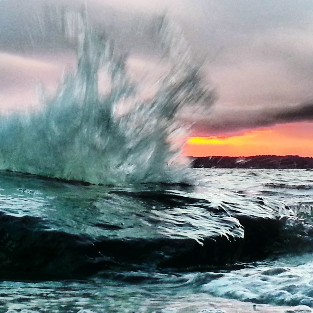 WAVES SPLASHING ON ROCKS AT SUNSET