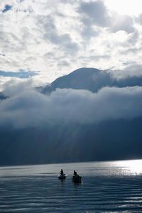 People on sea against sky