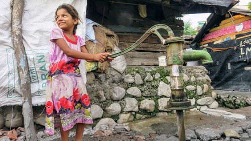 Portrait of woman standing against brick wall