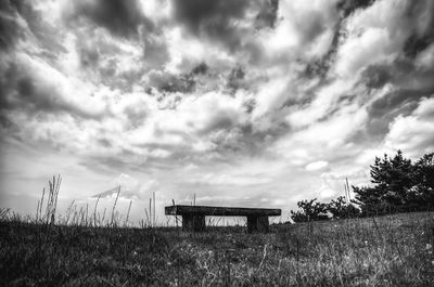 Scenic view of grassy field against cloudy sky