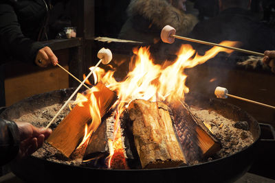 People preparing food on barbecue grill