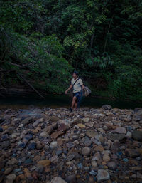 Woman standing on rock in forest