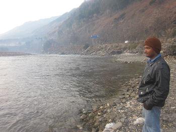 Full length of man standing on shore against sky