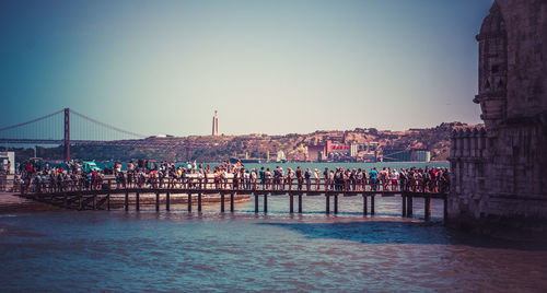 Group of people on bridge over sea