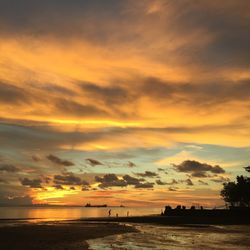 Scenic view of sea against dramatic sky during sunset