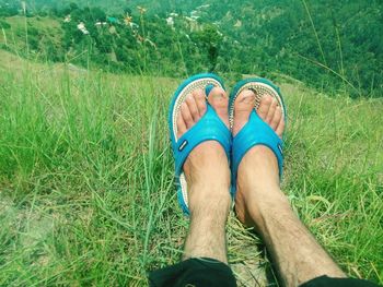 Low section of person wearing shoes on field