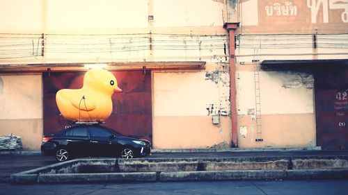 Toy car on street against wall