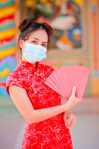 Woman wearing mask while holding papers