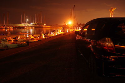 Boats moored in harbor at night