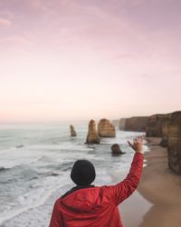 Rear view of man standing in front of sea