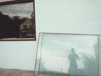 Reflection of man on glass window of building