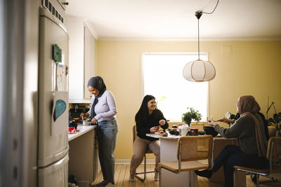 Happy young women preparing food enjoying in kitchen at home