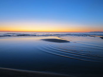 Scenic view of sea against clear sky during sunset