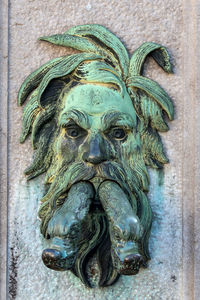 Close-up of old statue against wall