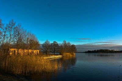 Scenic view of calm lake against blue sky